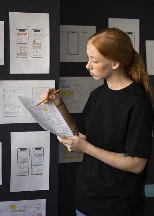 female-web-designer-taking-notes-office